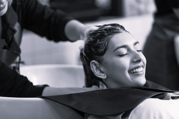 Una mujer se está lavando el cabello en una peluquería.