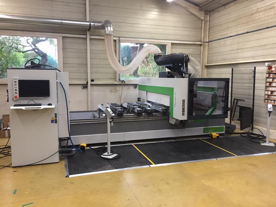 Une grande machine de fraisage CNC industrielle avec un tuyau d'aspiration des poussières dans un atelier bien éclairé.