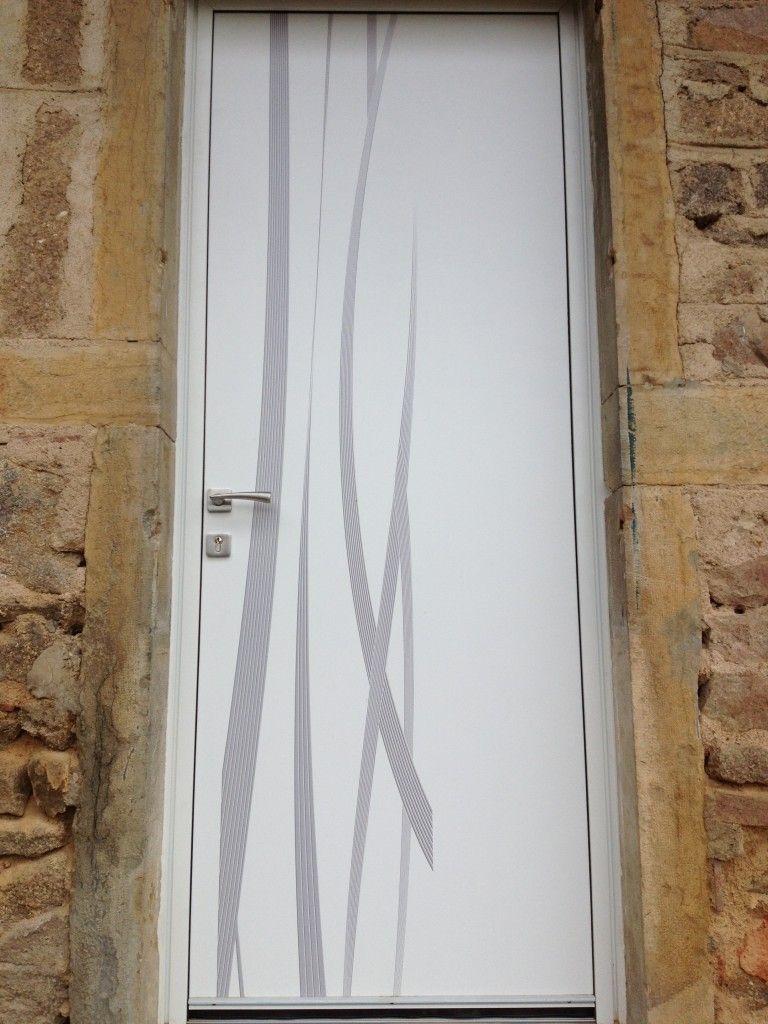 Une porte blanche moderne ornée de lignes verticales grises abstraites, encadrée par un cadre en pierre rustique et texturée.