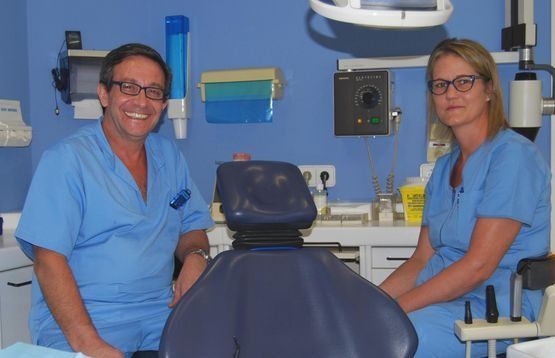 Un hombre y una mujer están sentados en una silla dental.