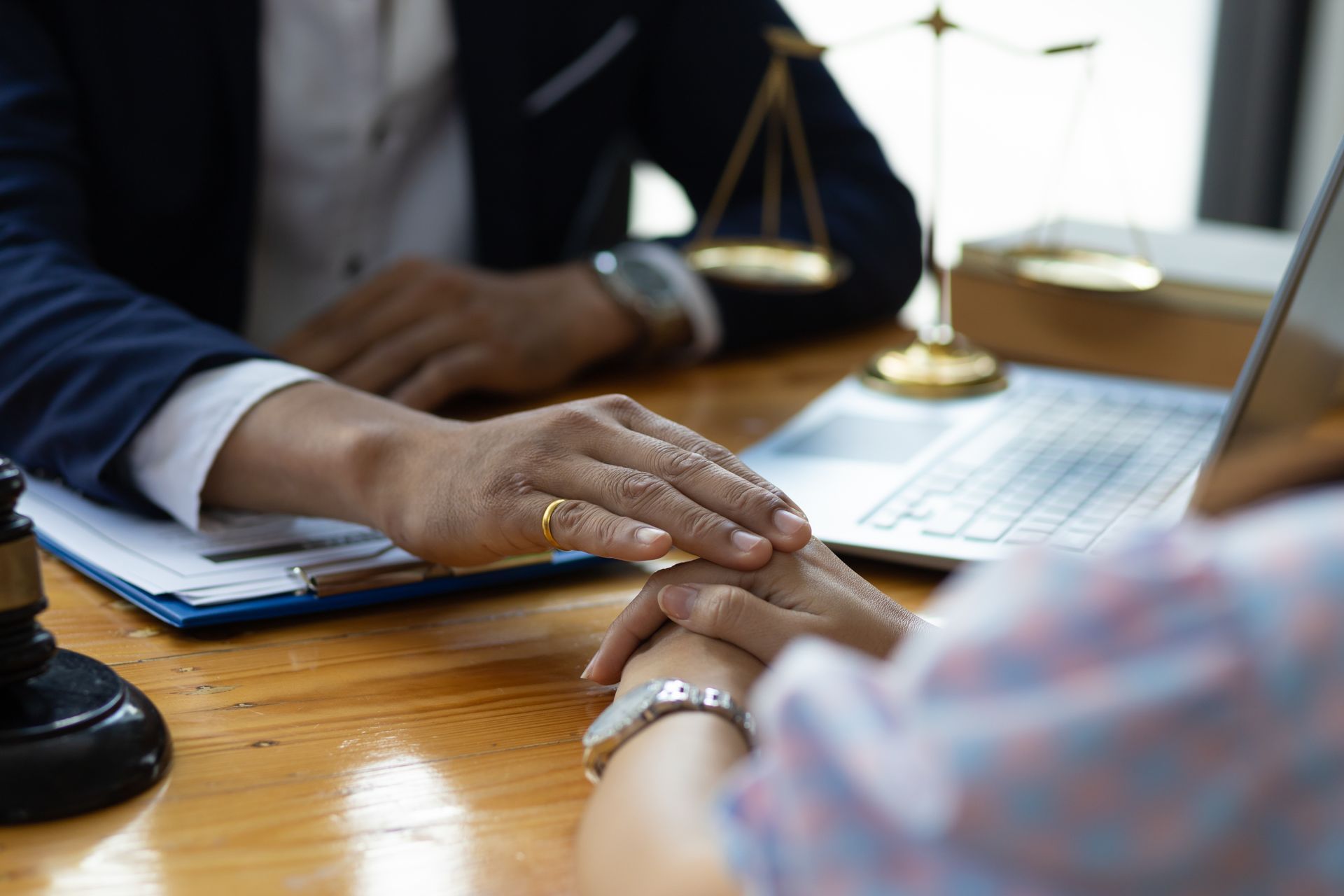 Avocat posant sa main sur celle de sa cliente pour la réconforter