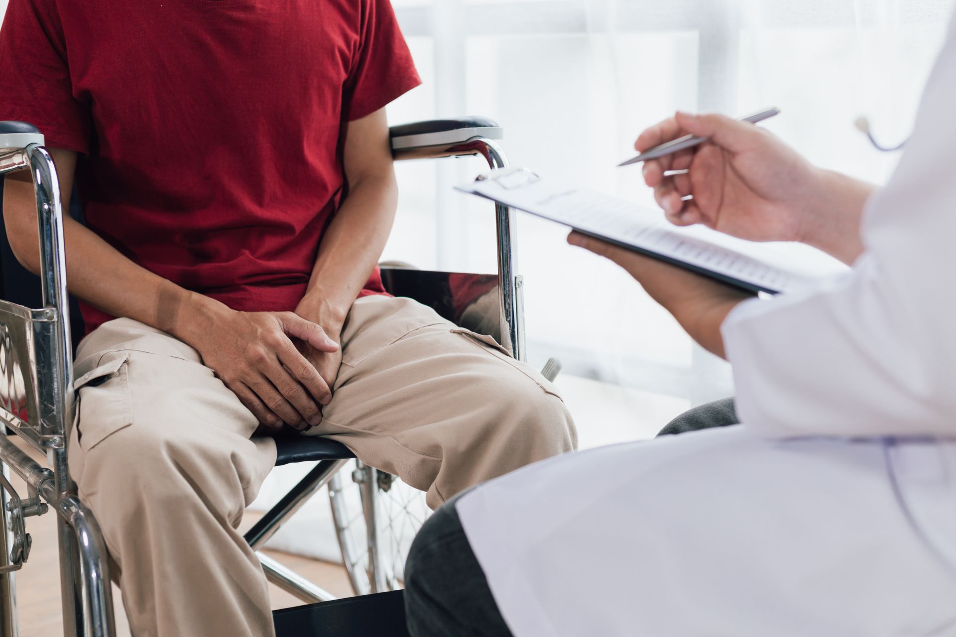 Homme en fauteuil roulant devant un médecin
