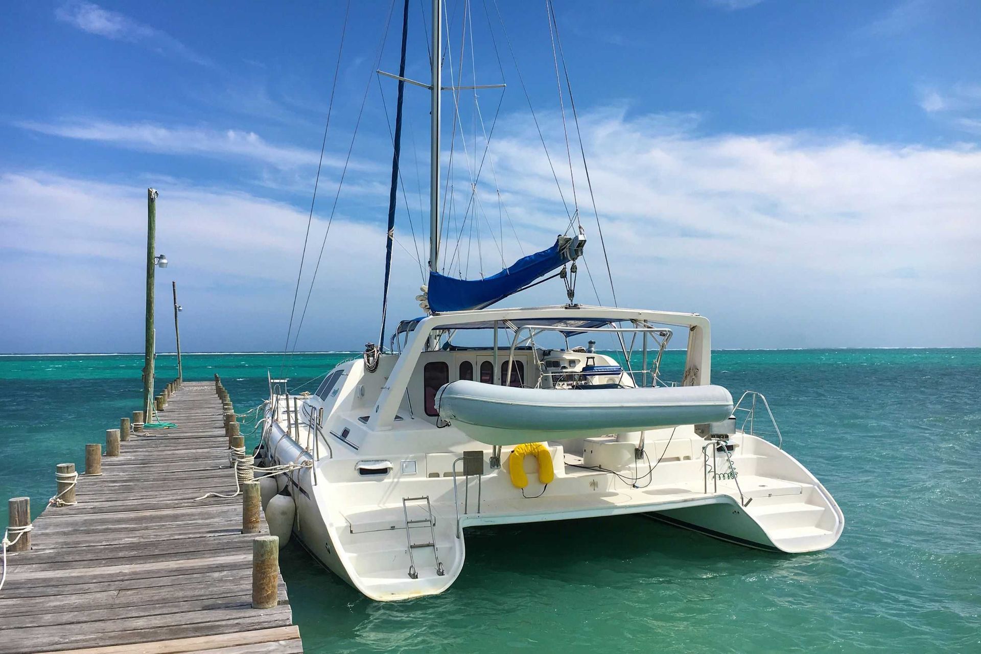 Un catamarán está atracado en un muelle en el océano.