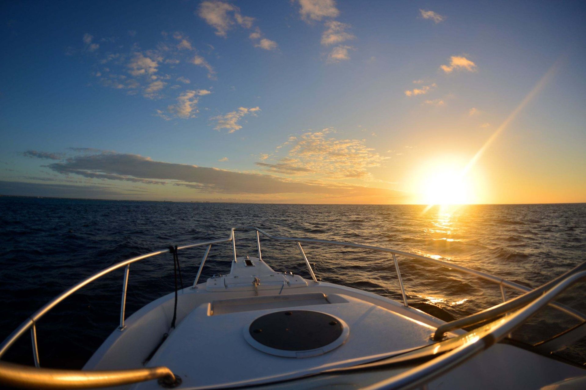 Un barco flota sobre un cuerpo de agua al atardecer.