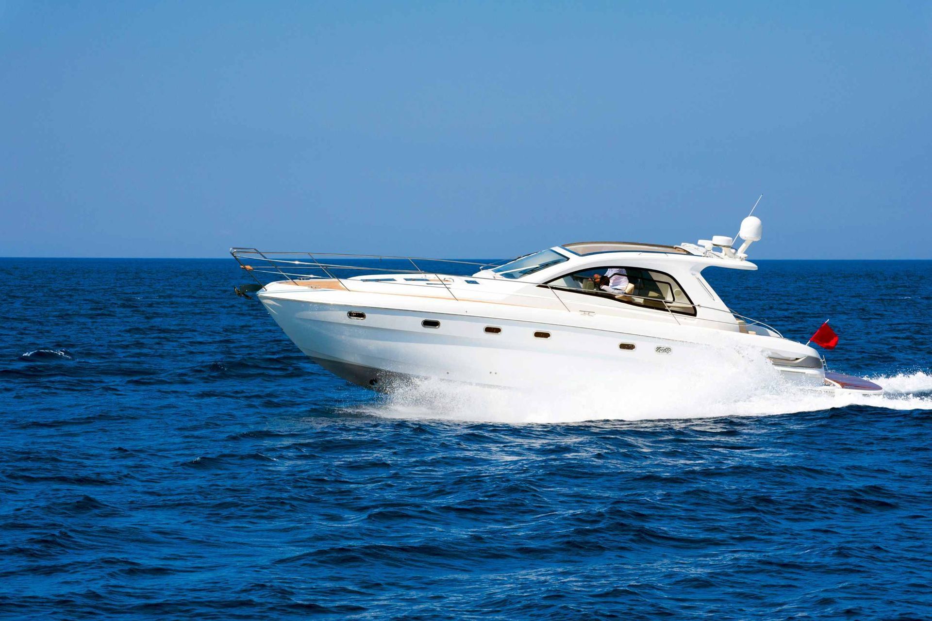 Un barco blanco flota sobre una gran masa de agua.
