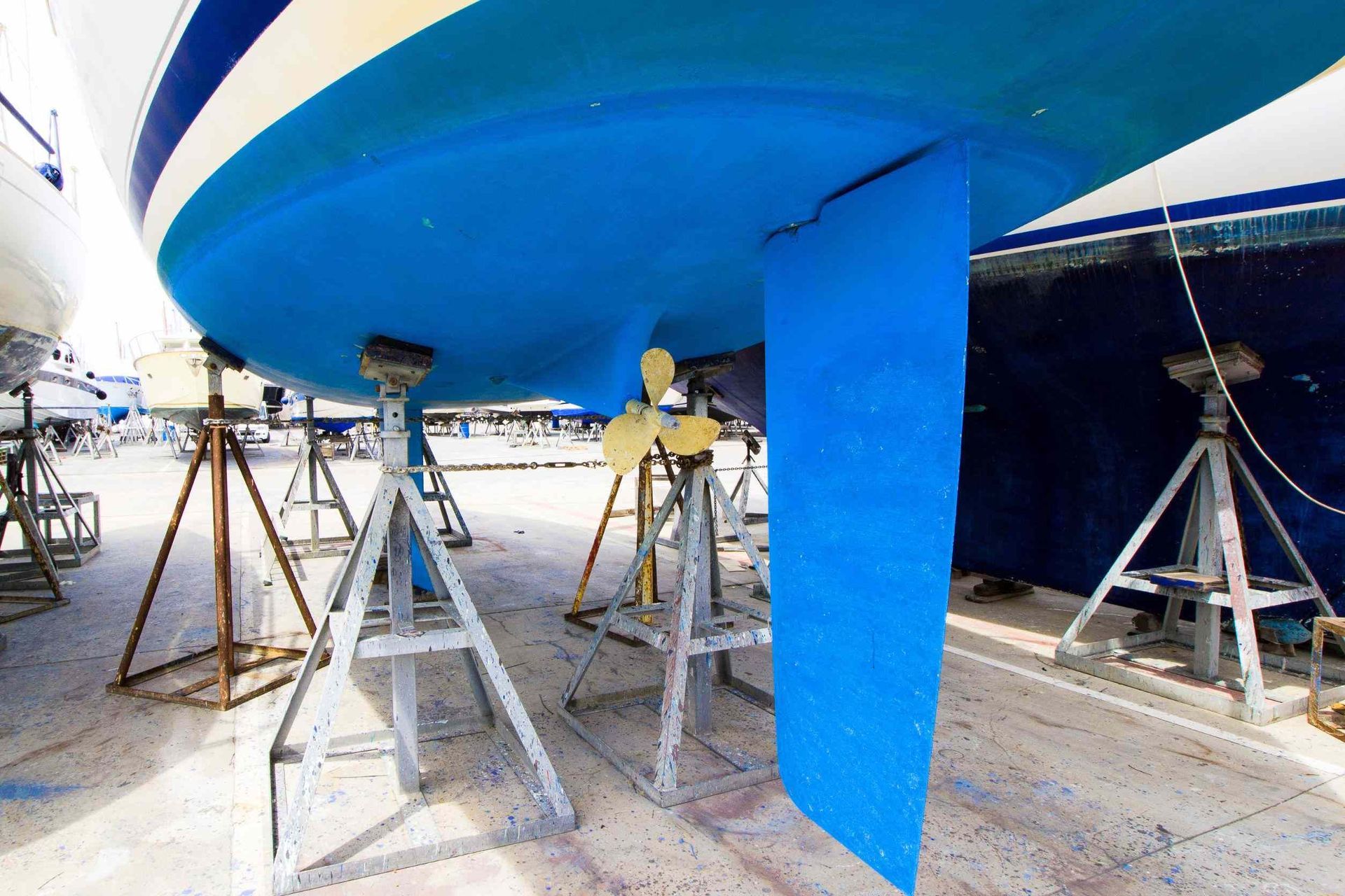 Un barco con una hélice azul está sentado en un muelle.