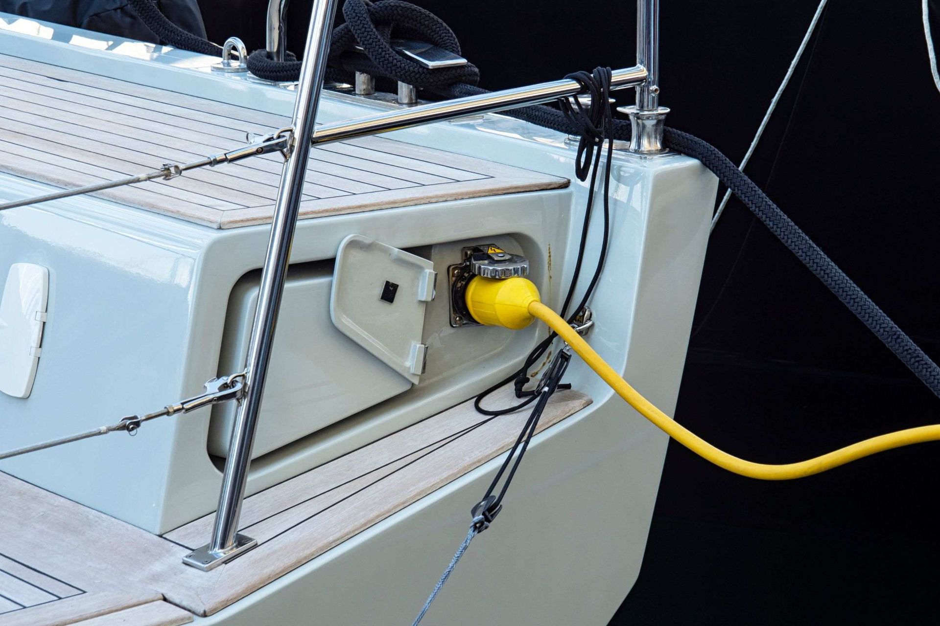Un cable amarillo está enchufado al costado de un barco.