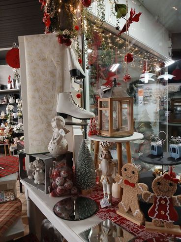 Vitrine de magasin décorée pour Noël, avec des décorations, des patins à roulettes et des figurines en pain d'épice.