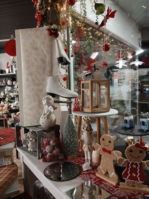 Vitrine de magasin décorée pour Noël, avec des décorations, des patins à roulettes et des figurines en pain d'épice.