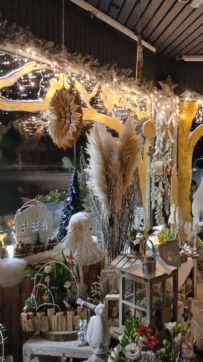 Décoration intérieure avec ornements de saison : herbes de la pampa, guirlandes lumineuses, maisons miniatures et compositions florales.