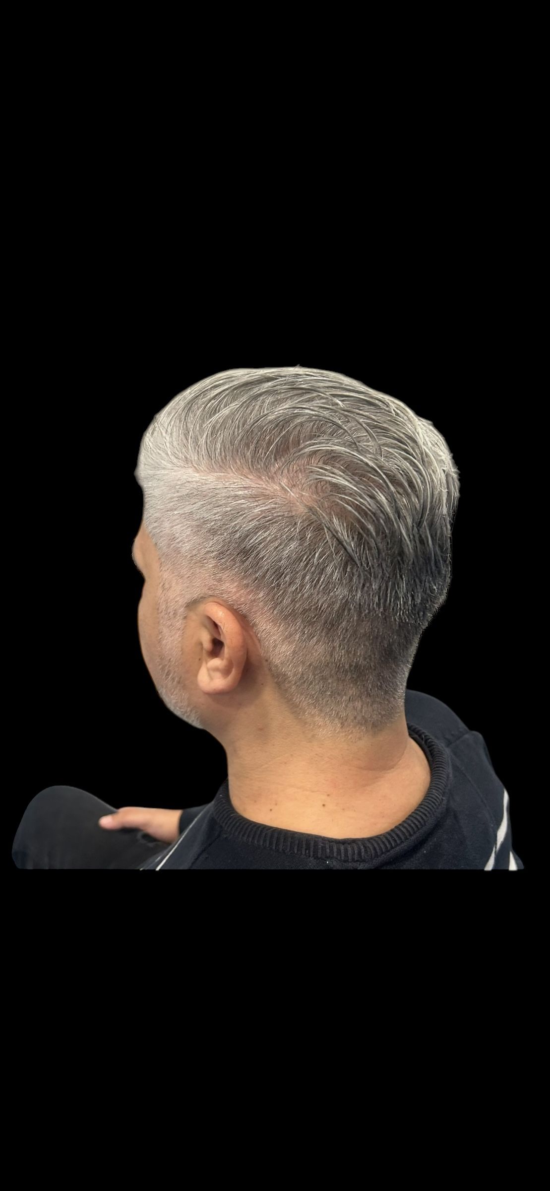 Ein Mann mit grauen Haaren und Bart sitzt auf einem Stuhl. Foto von der Hairstyling Ricci e Capricci GmbH