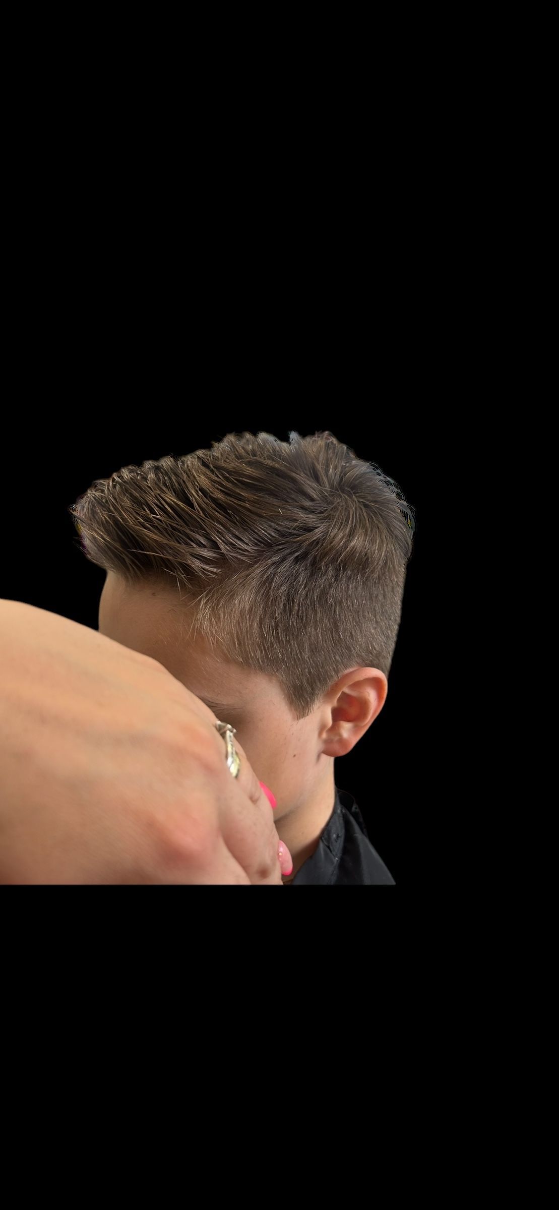 Ein kleines Mädchen mit langen braunen Haaren steht vor einer weissen Wand. Foto von der Hairstyling Ricci e Capricci GmbH