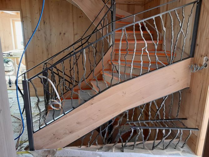 Un escalier en bois avec une rampe en fer forgé | JB Salamin Métal-création