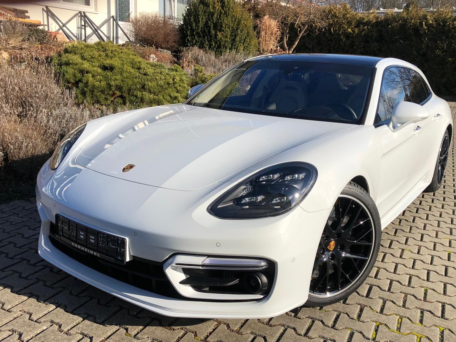 In einem Ausstellungsraum ist eine Reihe von Autos geparkt.