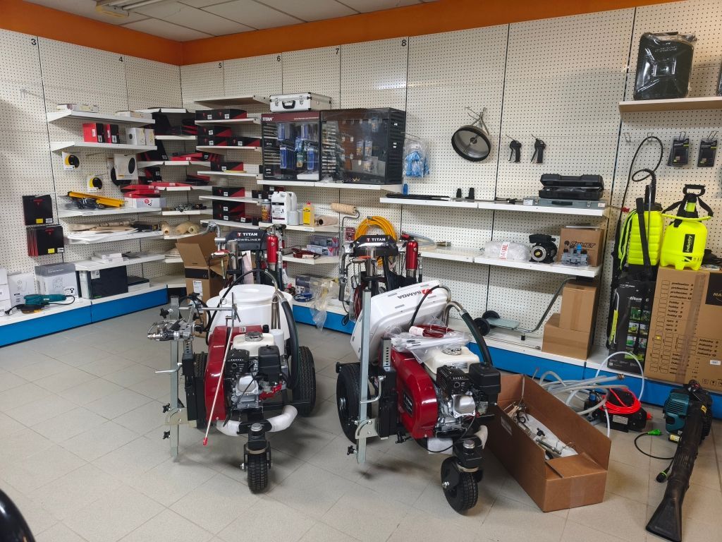 Atelier avec deux machines rouges et blanches devant des étagères et des outils.