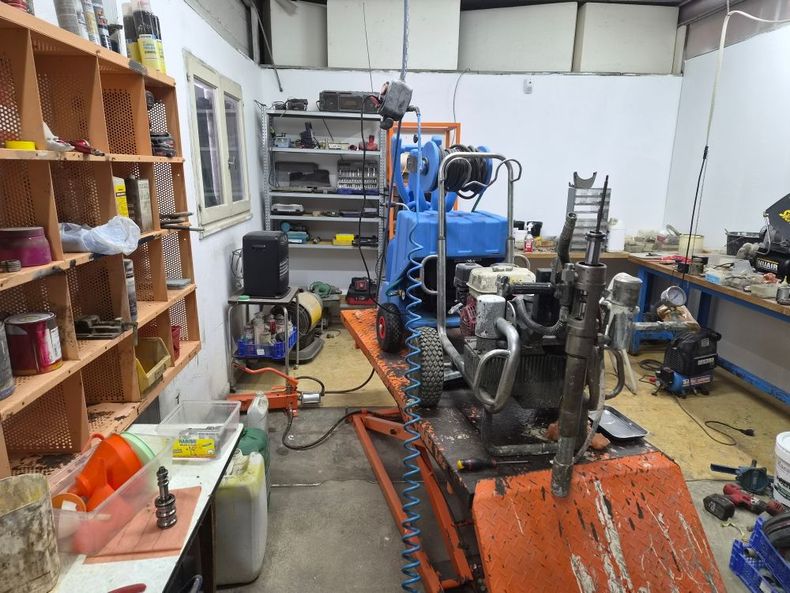 Atelier industriel avec une machine à chenilles et un moteur dans un atelier