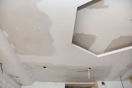 Une personne enduit un mur avec une truelle.