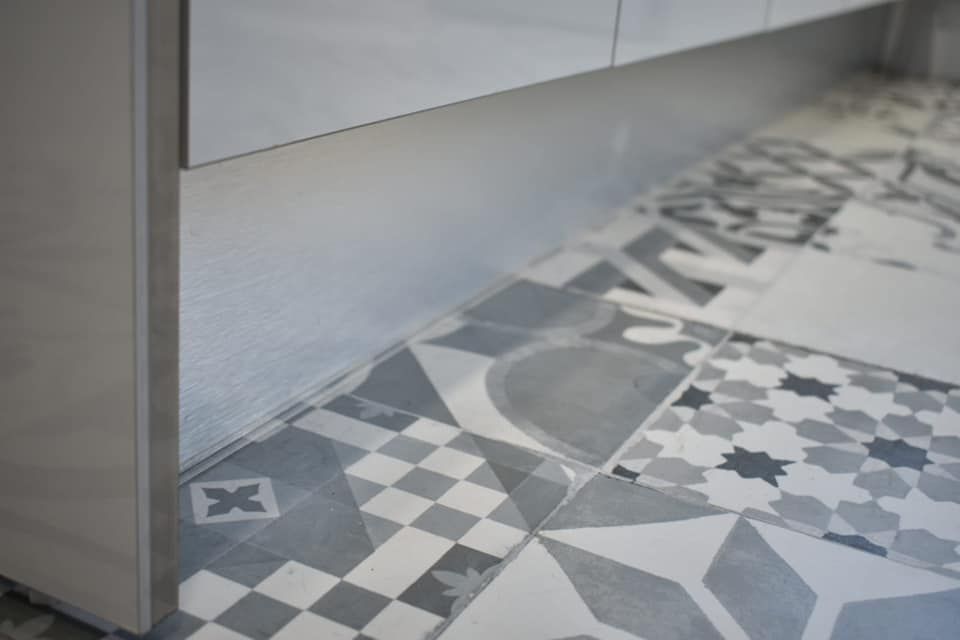 Un primer plano de un suelo de baldosas en una cocina.