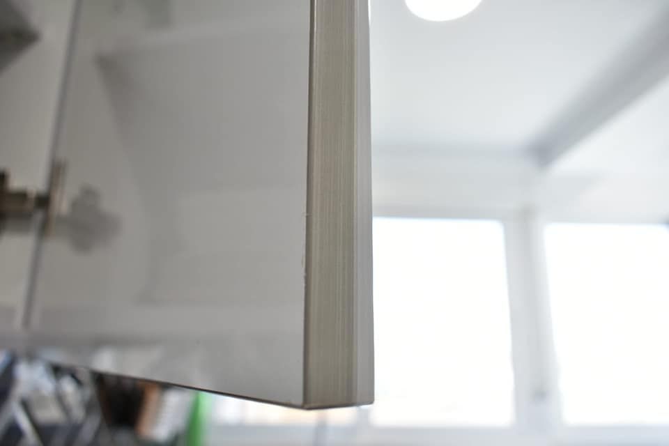 Un primer plano de una puerta de armario blanca en una cocina.