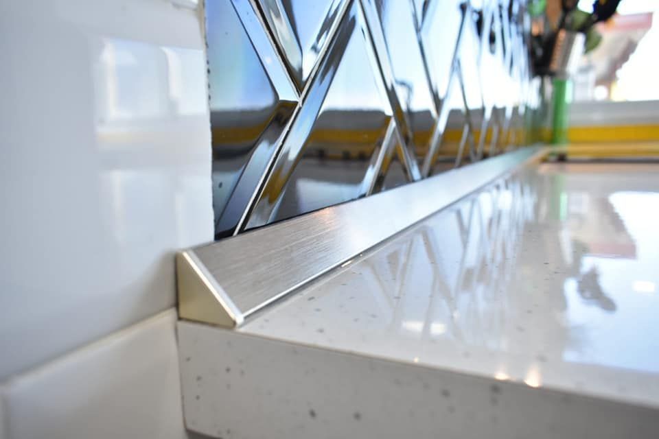 Un primer plano de una encimera de cocina con moldura de acero inoxidable.