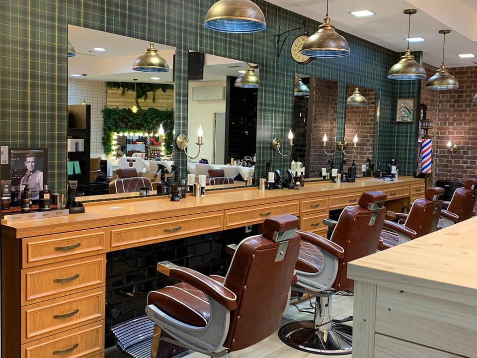 Una barbería con muchas sillas y espejos.