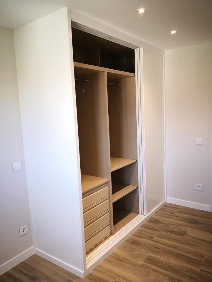 Un dormitorio con vestidor y piso de madera.