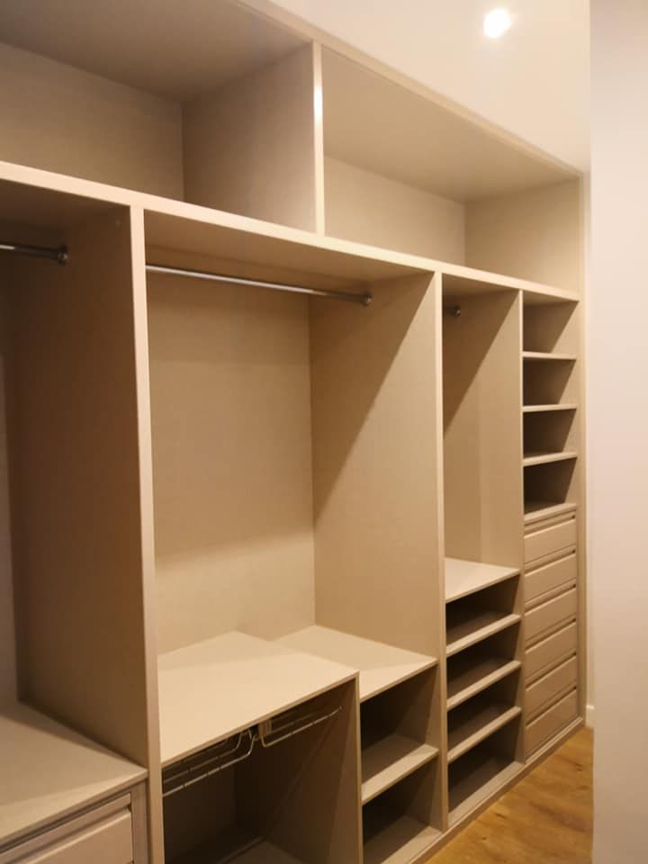 Un vestidor con muchos estantes y cajones.