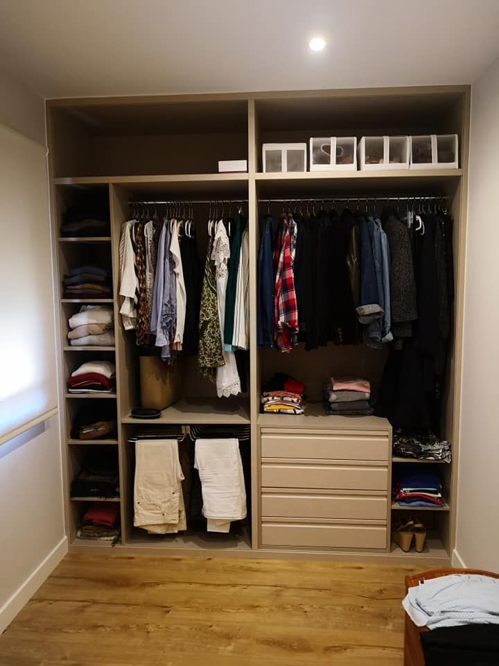 Un armario lleno de mucha ropa y cajones.