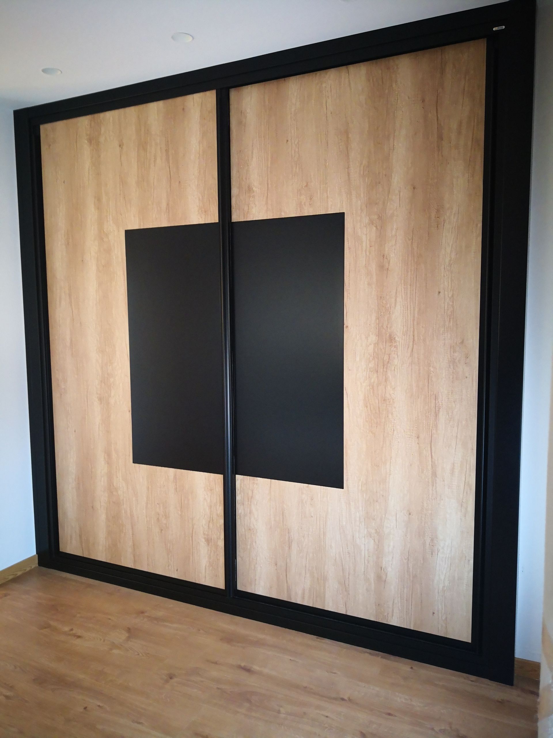 Una gran pared de madera con un cuadrado negro en el medio.