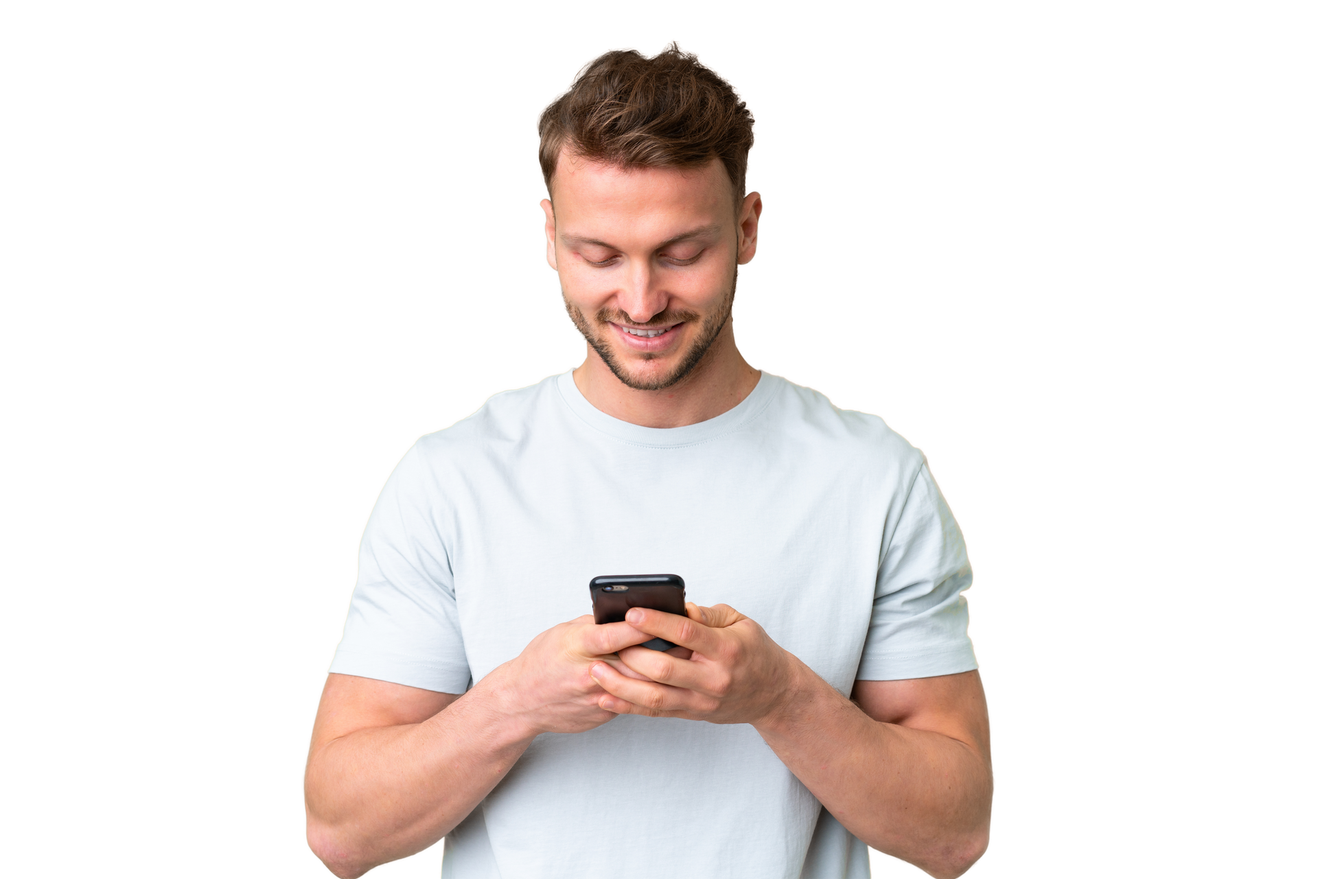 Un homme souriant, vêtu d'une chemise gris clair, regarde son téléphone sur fond blanc.