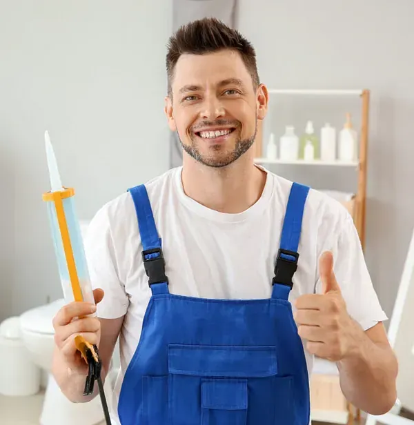 Un hombre con un mono azul sostiene una botella de pegamento y hace un gesto de aprobación con el pulgar hacia arriba.