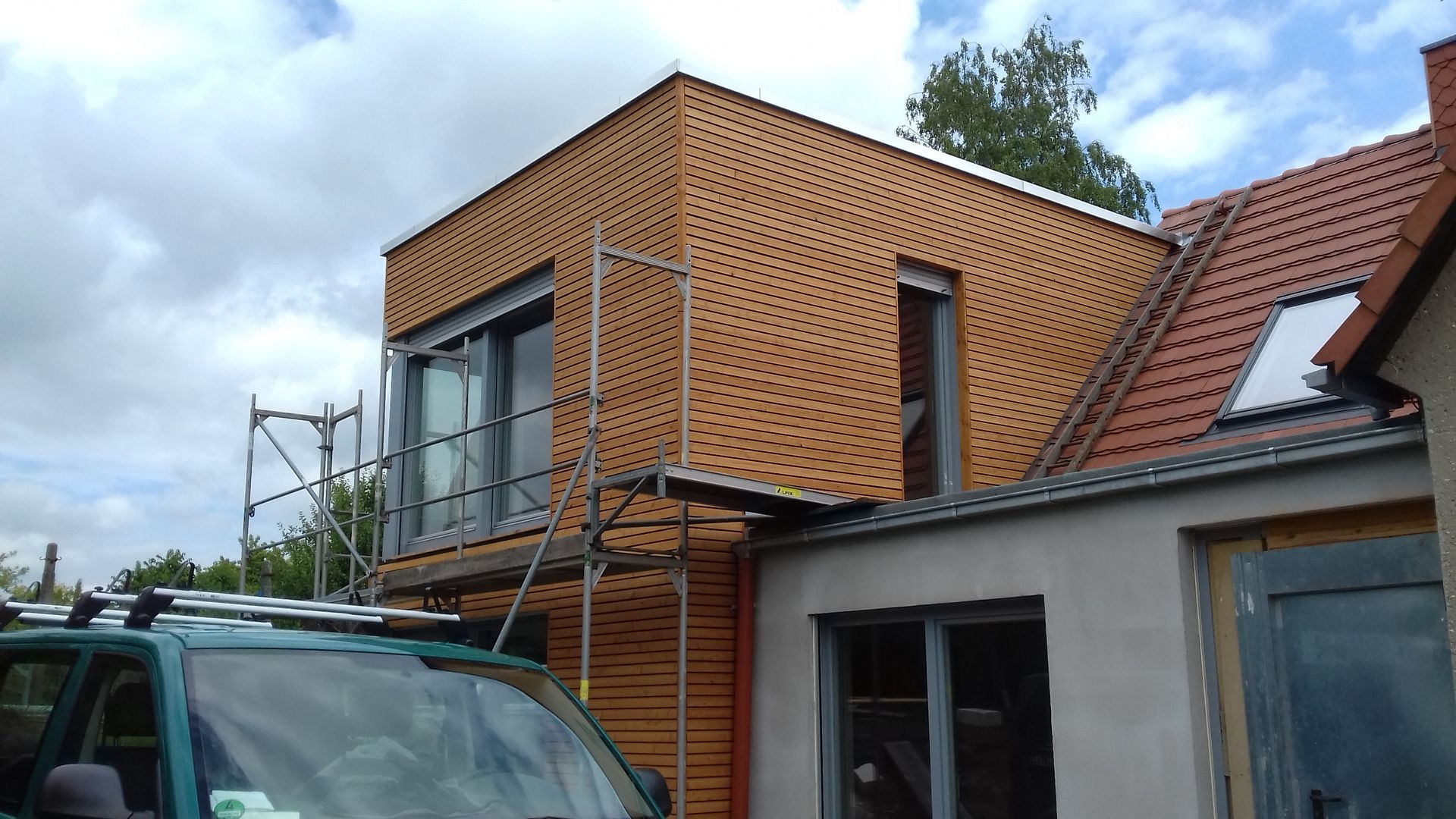 Moderne Fassadenverkleidung aus Holz an Wohnhaus in Dresden Wachwitz, Anbau mit Flachdach und Gerüst