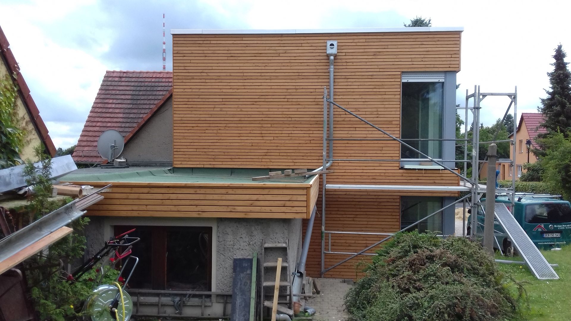 Sanierter Hausanbau mit Holzfassade und Flachdach in Dresden Wachwitz, Dachabdichtung und Aufbauarbeiten