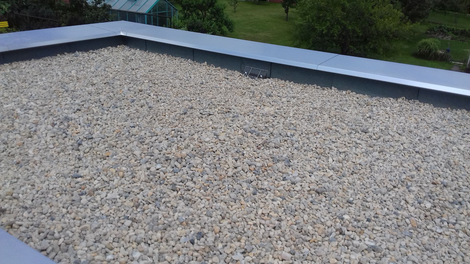 Fertiggestelltes Flachdach mit Kiesauflage, langlebige Dachabdichtung und Entwässerungssystem
