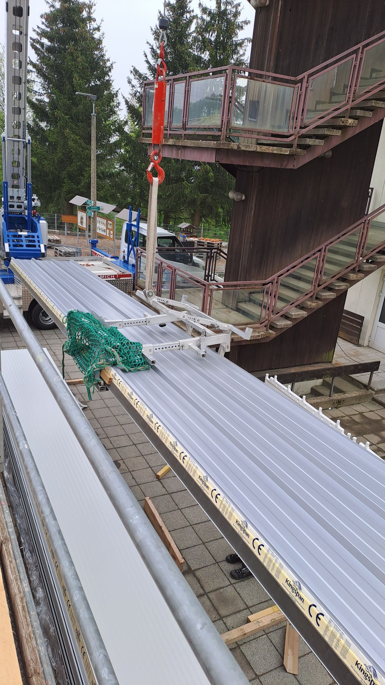 Gelagerte Trapezblechplatten auf einer Baustelle, vorbereitet für die Dachmontage.