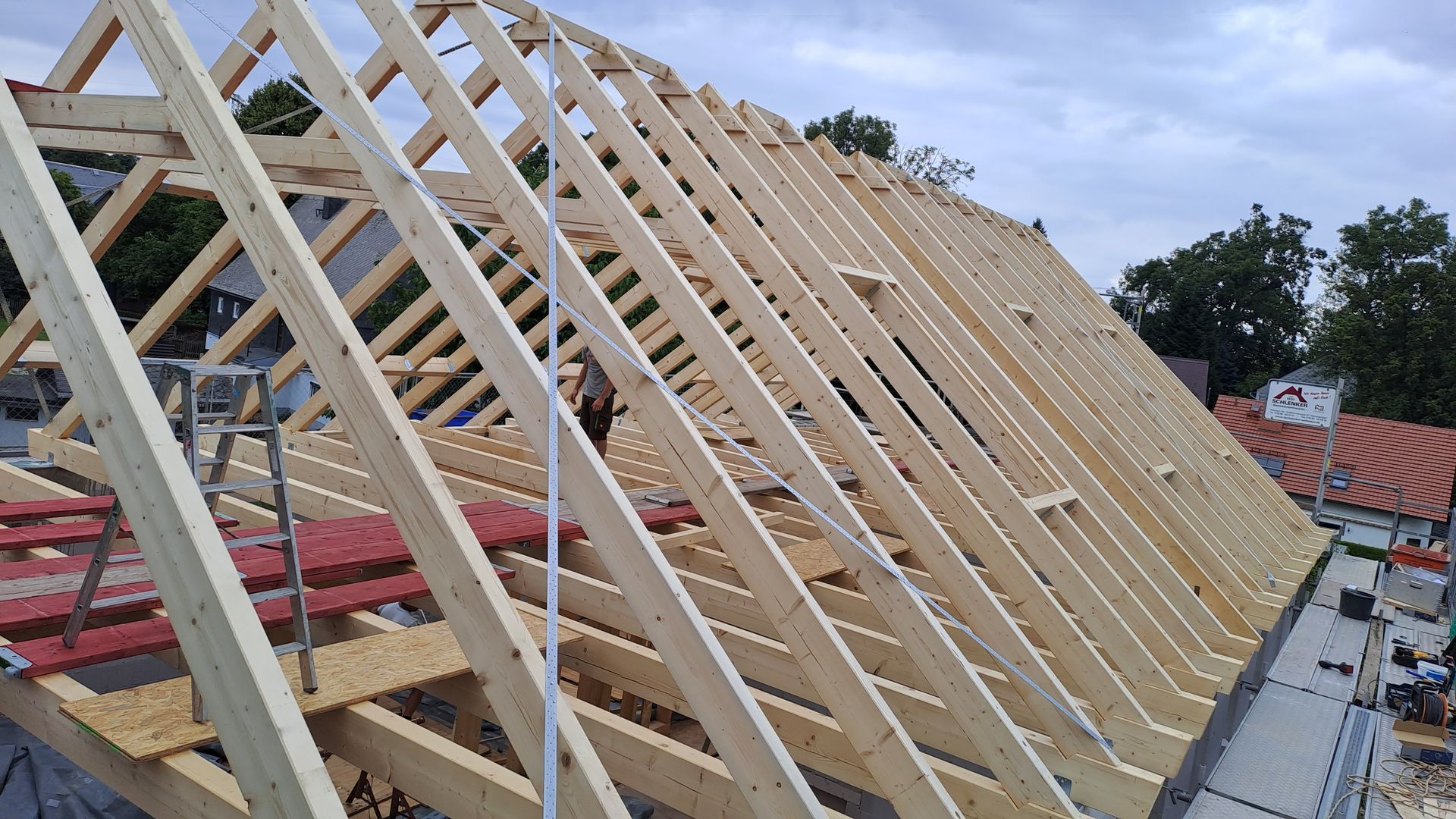 Detailansicht eines geneigten Dachstuhls mit gleichmäßig angeordneten Holzsparren.