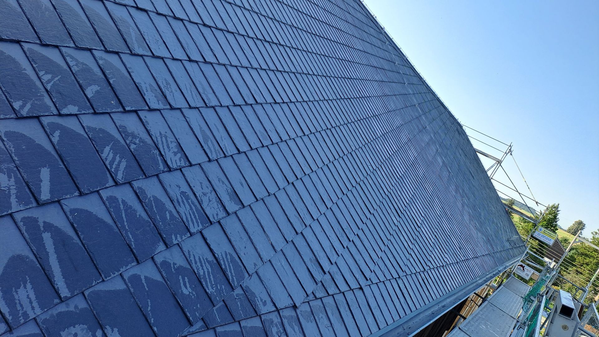 Detailansicht einer Schieferdeckung auf Dachfläche, präzise verlegte Schieferplatten