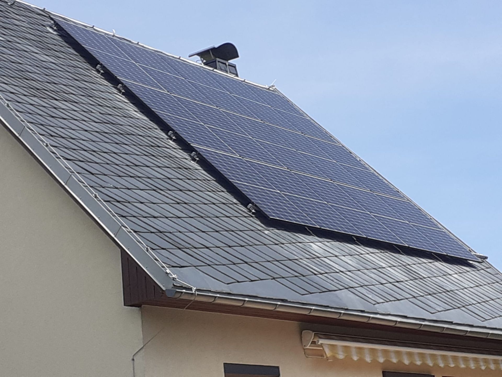 Photovoltaikanlage auf geneigtem Dach mit gleichmäßig angeordneten Solarmodulen zur Stromerzeugung
