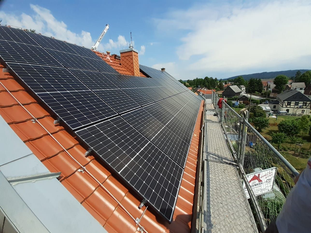 Großflächige Photovoltaikanlage auf Steildach mit Gerüst, Solarmodule in Reihe montiert