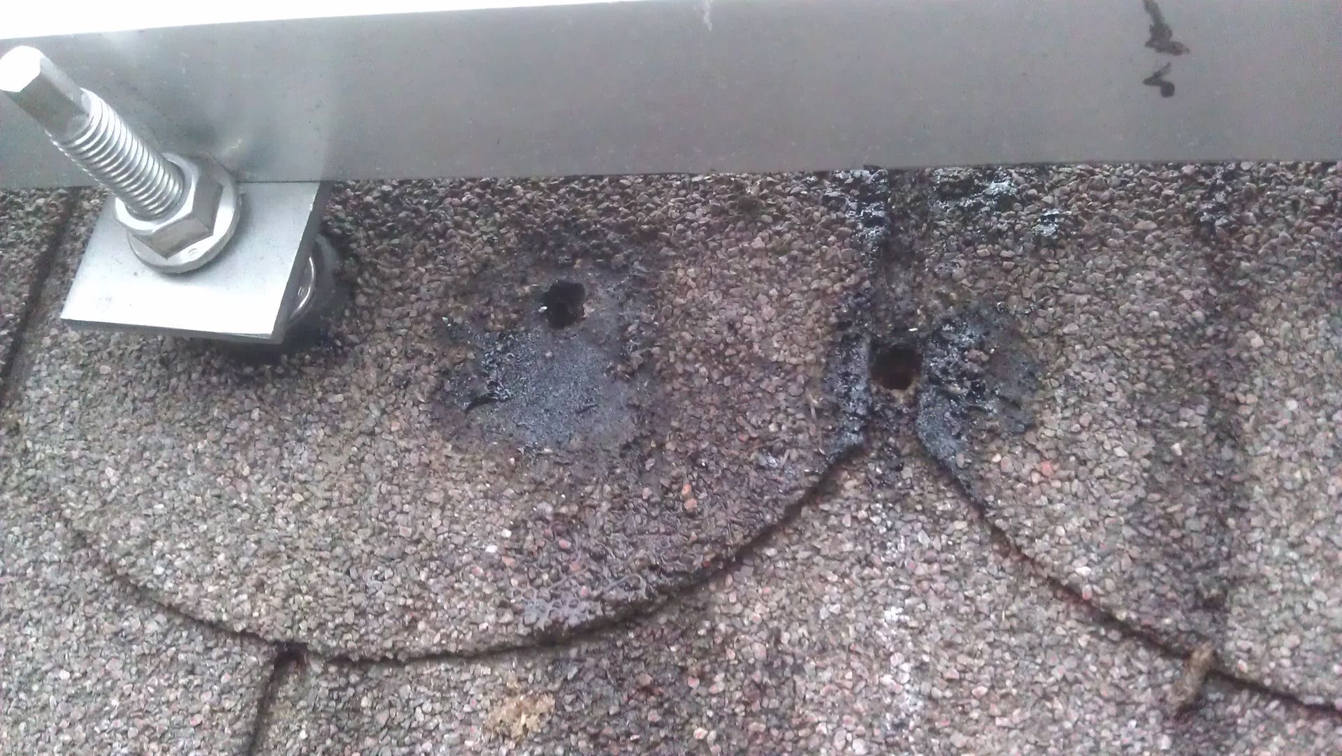 Undichte Befestigungspunkte auf Ziegeldach mit offenen Bohrlöchern und Wasserschäden durch falsche Montage