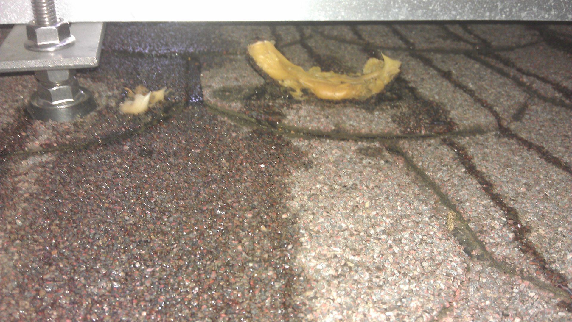 Beschädigte Dachfläche mit unsauber aufgetragener Dichtmasse, mangelhafte Abdichtung durch fehlerhafte Ausführung