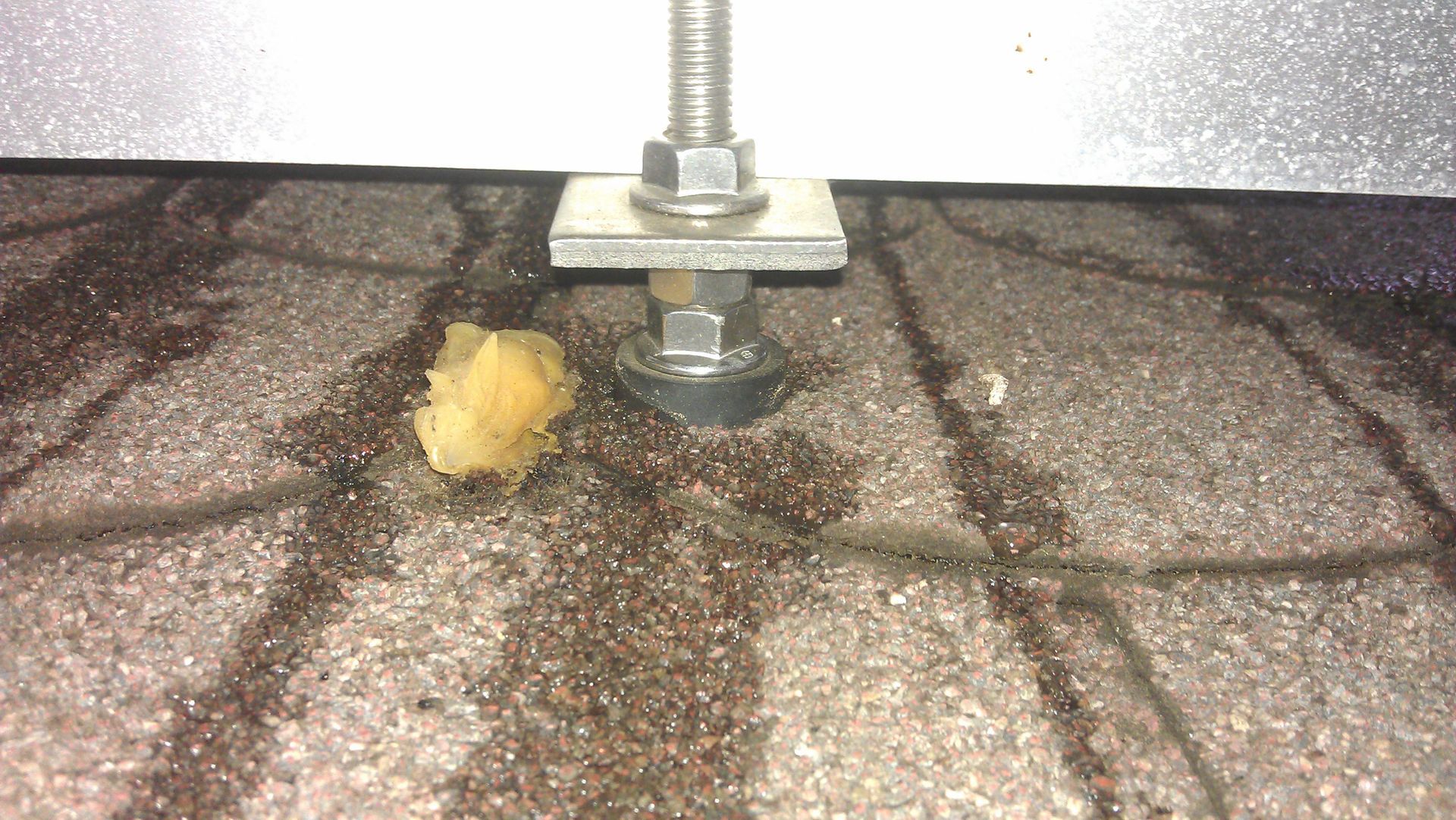 Unsachgemäß montierte Dachdurchführung mit Schraubverbindung und Dichtmasse, Feuchtigkeitsschäden am Dach erkennbar