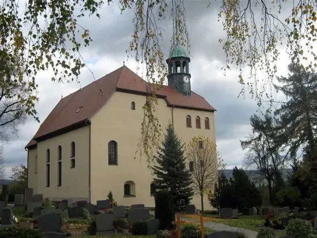 Kirchendach mit Turm vor der Sanierung, historische Kirche mit Ziegeldach und Friedhof im Vordergrund