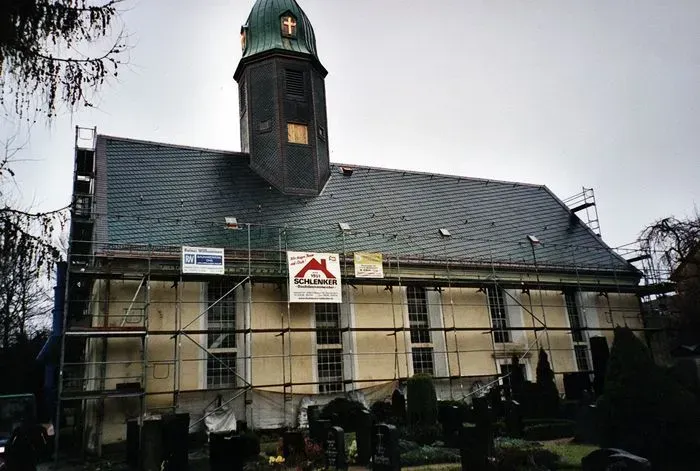 Kirche während Dachsanierung mit Baugerüst, Dachdeckerarbeiten am Kirchendach im Gange
