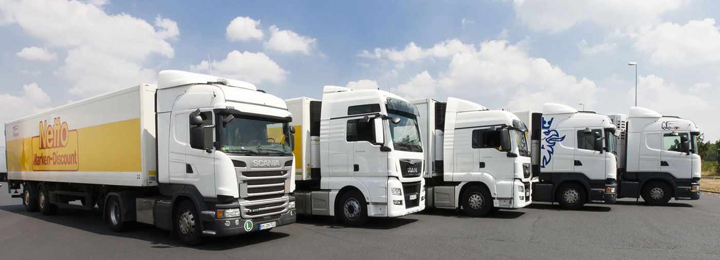 Eine Reihe weißer Lastwagen stehen nebeneinander