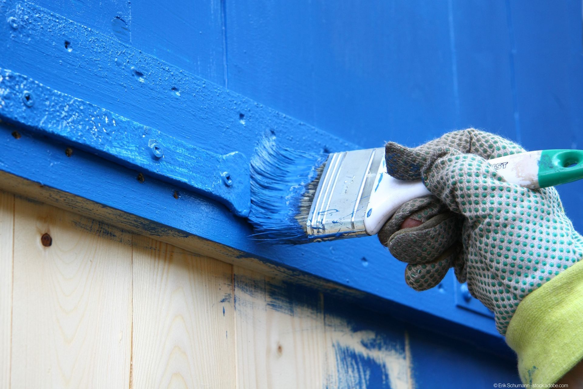 Arbeiter streicht mit blauer Farbe