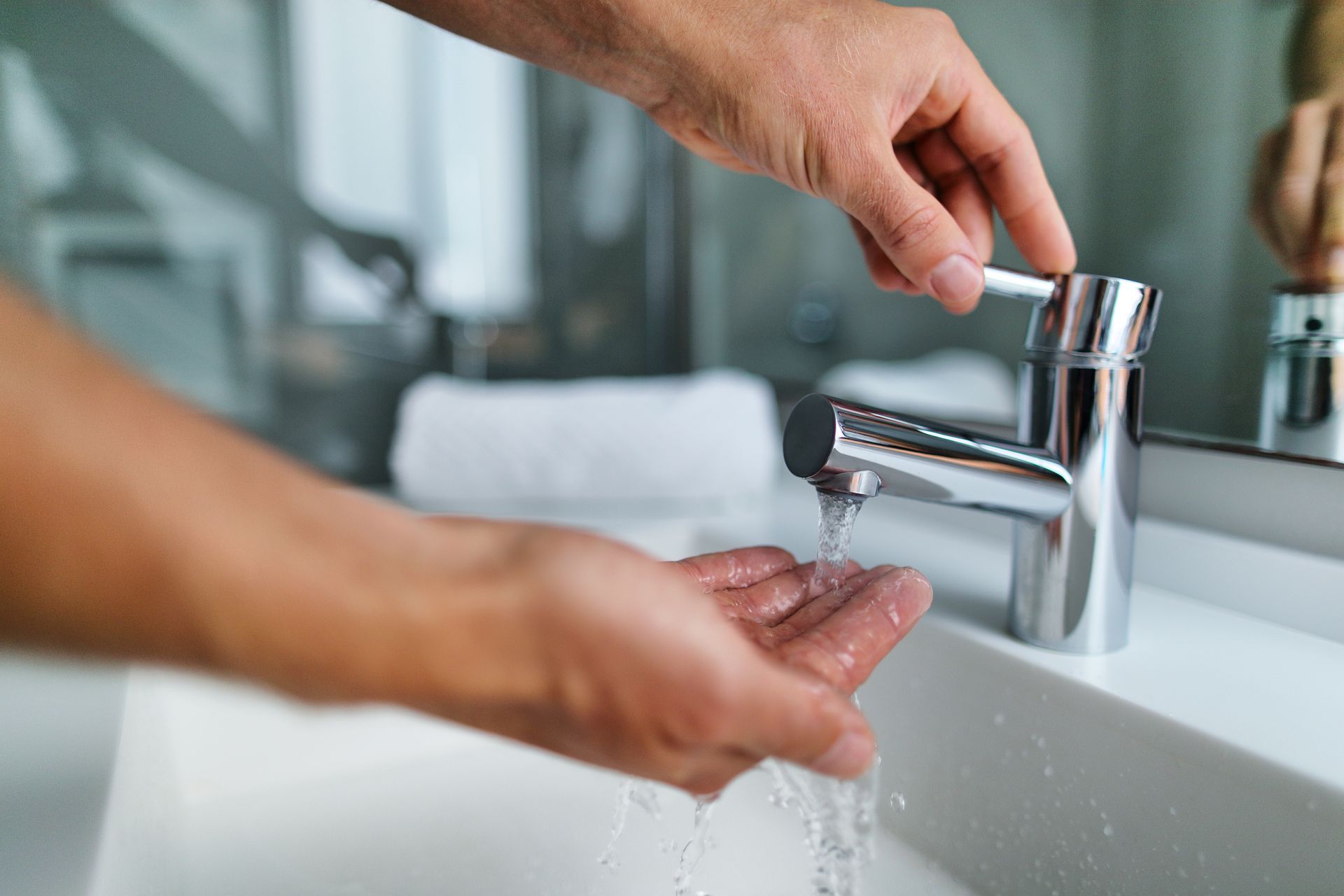 Une personne vérifie la température de l'eau avec sa main.