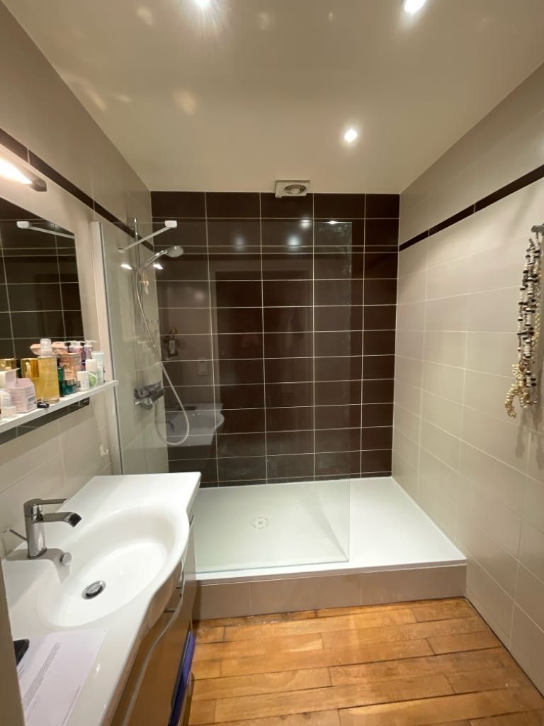 Rénovation de salle de bains avec une grande douche.