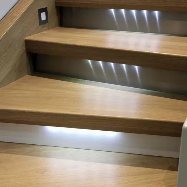 Un primer plano de una escalera de madera con luces en los escalones.