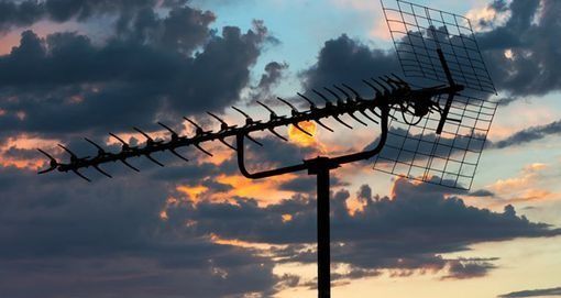 Una antena se recorta contra un cielo nublado al atardecer.